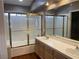 Bathroom featuring double sinks, wood cabinets, and shower with glass doors at 5201 S Torrey Pines Dr # 1253, Las Vegas, NV 89118