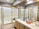 Bright bathroom with double sinks, bathtub and shower with tile and glass doors at 5201 S Torrey Pines Dr # 1253, Las Vegas, NV 89118