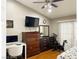 Bedroom featuring a closet, tv, desk, ceiling fan, and mirrored dresser at 5201 S Torrey Pines Dr # 1253, Las Vegas, NV 89118