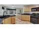 Kitchen features black appliances, tile countertops, breakfast nook and wood cabinets at 5373 Painted Mirage Rd, Las Vegas, NV 89149