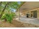 Inviting covered patio area, complete with a grill and framed by mature trees and lush landscaping at 5373 Painted Mirage Rd, Las Vegas, NV 89149