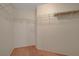 Spacious walk-in closet featuring ample shelving and wood flooring for optimal storage and organization at 5373 Painted Mirage Rd, Las Vegas, NV 89149