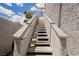 View of a white exterior staircase leading up to condos with blue sky and some vegetation at 5516 Orchard Ln # 0, Las Vegas, NV 89110