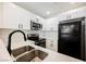 Modern kitchen with stainless steel appliances, black refrigerator, white cabinetry and tile backsplash at 5516 Orchard Ln # 0, Las Vegas, NV 89110
