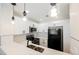 Modern kitchen with stainless steel appliances, black refrigerator, white cabinetry and tile backsplash at 5516 Orchard Ln # 0, Las Vegas, NV 89110