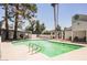 Community swimming pool with clear water, surrounded by trees, lounge chairs and tables for outdoor enjoyment at 5516 Orchard Ln # 0, Las Vegas, NV 89110