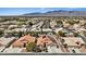Aerial view highlights a residential neighborhood with solar panels on roofs and mountain views in the distance at 5812 Spinnaker Reach Ave, Las Vegas, NV 89130