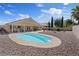Beautiful backyard features a pool, desert landscaping, and covered patio at 5812 Spinnaker Reach Ave, Las Vegas, NV 89130