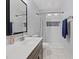 Bright bathroom featuring white tiles, a large mirror, and dark wood-colored cabinetry at 5812 Spinnaker Reach Ave, Las Vegas, NV 89130