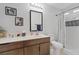 Cozy bathroom featuring a tub and shower with white tiles and wood-colored cabinetry at 5812 Spinnaker Reach Ave, Las Vegas, NV 89130