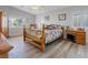 Cozy bedroom featuring neutral walls, wood-look flooring, a large window and ample sunlight at 5812 Spinnaker Reach Ave, Las Vegas, NV 89130
