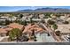 An aerial view shows a house with a three car garage, solar panels, desert landscaping and mountain views at 5812 Spinnaker Reach Ave, Las Vegas, NV 89130