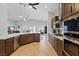 Open kitchen flows into living and dining spaces with modern stainless appliances and eat-in counter at 5812 Spinnaker Reach Ave, Las Vegas, NV 89130