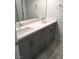 Bathroom featuring double sinks, modern fixtures, and gray cabinets at 6450 Spring Jog St, Las Vegas, NV 89166