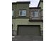Attached two-car garage with complementary stone accents and lush landscaping at 6450 Spring Jog St, Las Vegas, NV 89166