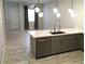 Modern kitchen features gray cabinets, stainless steel dishwasher, and quartz countertops and a long tile floor at 6450 Spring Jog St, Las Vegas, NV 89166