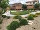 Well-maintained landscaping with lush greenery, decorative gravel, and walking path at 6450 Spring Jog St, Las Vegas, NV 89166
