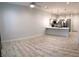 Spacious living room area with wood-look tile floors and modern light fixtures at 6450 Spring Jog St, Las Vegas, NV 89166