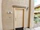 Condo entrance featuring a tan front door with stone accents and a modern light fixture at 6635 Flaminian Ln # 104, North Las Vegas, NV 89084
