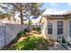 A backyard features a block wall with green grass and trees overhead at 7617 Sea Cliff Way, Las Vegas, NV 89128