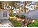 View of the backyard featuring a block wall and trees offering shade at 7617 Sea Cliff Way, Las Vegas, NV 89128