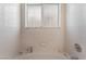 Minimalist bathroom with tile walls, soaking tub, and frosted window at 7617 Sea Cliff Way, Las Vegas, NV 89128