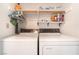 Functional laundry room with washer, dryer, shelving, and ample storage space for laundry essentials at 7617 Sea Cliff Way, Las Vegas, NV 89128