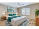 Bedroom virtually staged with a large bed, area rug, and natural light at 7949 Long Beach St, Las Vegas, NV 89139