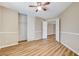 Bedroom with ample closet space, wood-look flooring, neutral walls, and bright ceiling fan at 7949 Long Beach St, Las Vegas, NV 89139