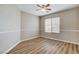 Neutral bedroom with a window providing natural light, a ceiling fan, and wood-look flooring at 7949 Long Beach St, Las Vegas, NV 89139