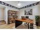 Home office features a desk with a laptop, a bookshelf, and a potted plant, all on a rug at 7949 Long Beach St, Las Vegas, NV 89139