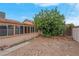 Backyard featuring desert landscaping, mature trees, and block fence at 8024 Hackberry Dr, Las Vegas, NV 89123