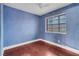 Bedroom with textured blue walls, white trim, hardwood flooring, and a window at 8024 Hackberry Dr, Las Vegas, NV 89123