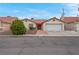 Well-kept single-story home with a red door, two-car garage, and desert landscaping at 8024 Hackberry Dr, Las Vegas, NV 89123