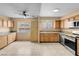 Bright kitchen featuring tiled flooring, wood cabinetry, a ceiling fan, and stainless steel appliances at 8024 Hackberry Dr, Las Vegas, NV 89123
