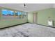 Bright living room features three large windows for ample natural light and neutral carpet with light green walls at 8024 Hackberry Dr, Las Vegas, NV 89123