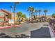 View of community entrance with clubhouse in background and lush landscaping on the sides at 8101 W Flamingo Rd # 1035, Las Vegas, NV 89147