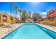 Community pool area featuring several lounge chairs, palm trees and desert landscaping at 8101 W Flamingo Rd # 1035, Las Vegas, NV 89147