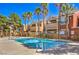 Community pool with palm trees, desert landscaping, and apartment buildings at 8101 W Flamingo Rd # 1035, Las Vegas, NV 89147