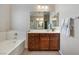 Bathroom with a soaking tub, wood vanity, and a large mirror above the sink at 820 Colina Alta Pl, Las Vegas, NV 89138