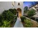 Welcoming front entrance with a covered archway, desert landscaping, and a well lit entry door at 820 Colina Alta Pl, Las Vegas, NV 89138