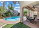 Outdoor patio with a dining table, chairs, and a view of the pool and landscaped backyard at 820 Colina Alta Pl, Las Vegas, NV 89138