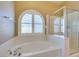 Bright bathroom showcasing a soaking tub with shutters and a glass-enclosed shower at 8204 Turbys Treehouse Pl, Las Vegas, NV 89131