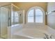 This bathroom features a shower, a soaking tub, and an arched shuttered window at 8204 Turbys Treehouse Pl, Las Vegas, NV 89131