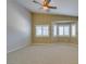 Spacious bedroom featuring a ceiling fan, neutral carpet, and bright bay windows with plantation shutters at 8204 Turbys Treehouse Pl, Las Vegas, NV 89131