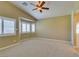 This primary bedroom boasts plush carpet, neutral paint, a ceiling fan, and a shuttered window at 8204 Turbys Treehouse Pl, Las Vegas, NV 89131