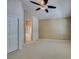 This bedroom features plush carpet, neutral paint, a ceiling fan, and a door to the ensuite bath at 8204 Turbys Treehouse Pl, Las Vegas, NV 89131