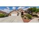 Charming single story home with a three car garage, desert landscaping, and a tile roof under sunny blue skies at 8204 Turbys Treehouse Pl, Las Vegas, NV 89131