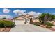 Charming single story home with a three car garage, desert landscaping, and a tile roof under sunny blue skies at 8204 Turbys Treehouse Pl, Las Vegas, NV 89131