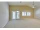 Spacious living room featuring neutral paint, carpet flooring, ceiling fan, and French doors to the backyard at 8204 Turbys Treehouse Pl, Las Vegas, NV 89131
